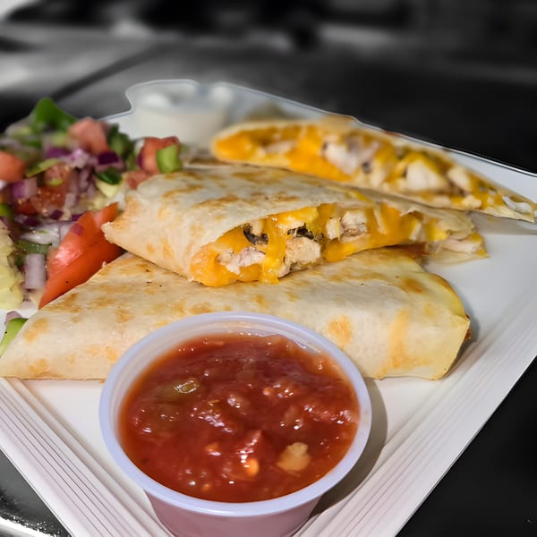 Chicken quesadillas with melted cheese, a side salad, and a cup of salsa on a white plate.